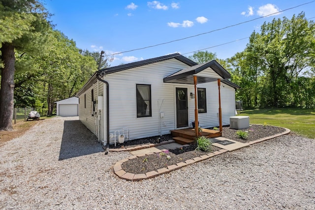 view of front of house with an outdoor structure and gravel driveway