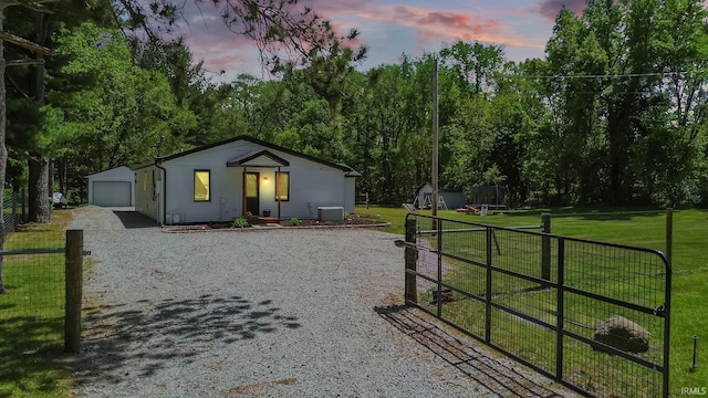 view of front facade featuring an outdoor structure, a garage, gravel driveway, and cooling unit