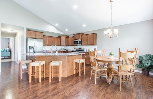 2108 Longway Ct, Evansville, IN 47711 - kitchen featuring stainless steel appliances, dark wood-style floors, brown cabinets, a kitchen island with sink, and a kitchen bar