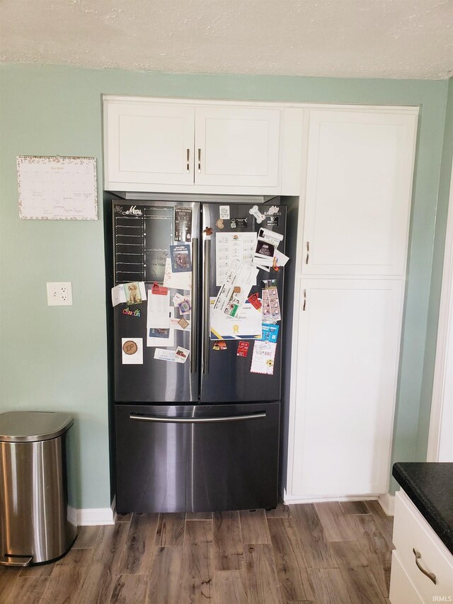 301 Raleigh Rd, Galveston, IN 46932 - kitchen featuring freestanding refrigerator, dark wood-type flooring, white cabinets, and baseboards