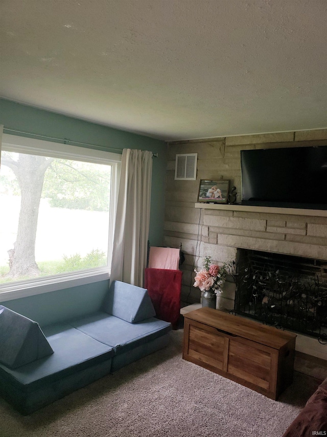 301 Raleigh Rd, Galveston, IN 46932 - carpeted living room featuring a textured ceiling and a fireplace
