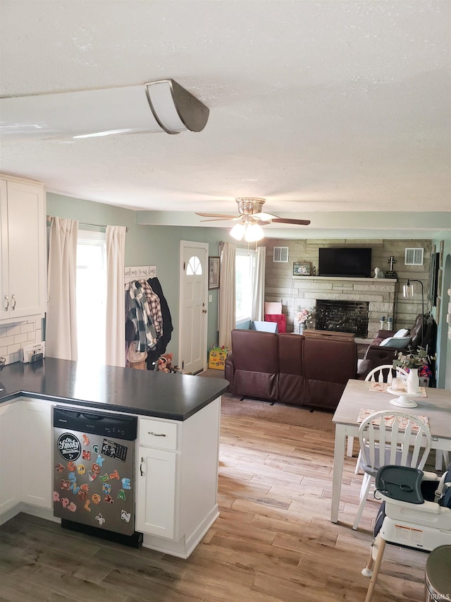 301 Raleigh Rd, Galveston, IN 46932 - kitchen featuring a peninsula, dark countertops, white cabinets, and light wood-style flooring
