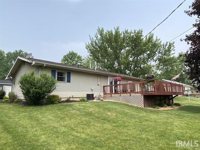 205 Holly Ln, Geneva, IN 46740 - back of property featuring a wooden deck, a lawn, and central AC unit
