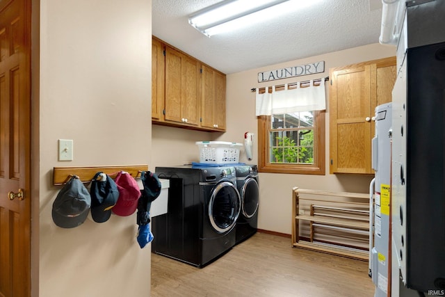 103 Ironwood Ave, Kendallville, IN 46755 - laundry room featuring cabinet space, separate washer and dryer, light wood-type flooring, a textured ceiling, and baseboards