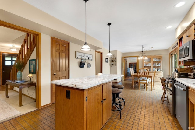 103 Ironwood Ave, Kendallville, IN 46755 - kitchen with appliances with stainless steel finishes, a kitchen island, plenty of natural light, decorative light fixtures, and recessed lighting