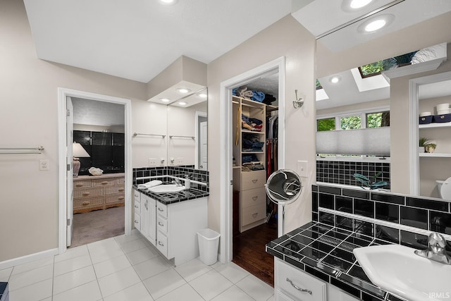 125 Durkees Run Dr, Lafayette, IN 47905 - bathroom with a skylight, tasteful backsplash, a walk in closet, vanity, and tile patterned flooring