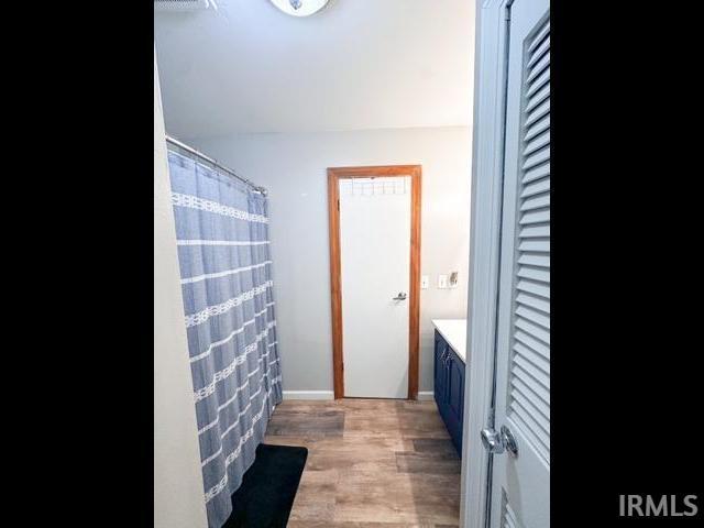 11239 Thomas Dr, Evansville, IN 47712 - full bathroom featuring wood finished floors, vanity, and a closet