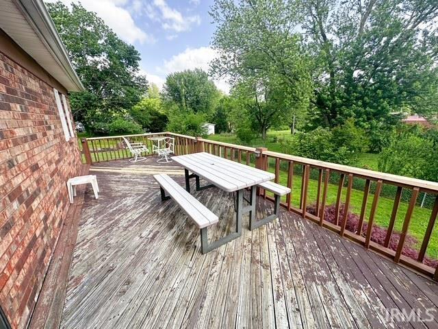 11239 Thomas Dr, Evansville, IN 47712 - wooden deck featuring outdoor dining space and view of wooded area