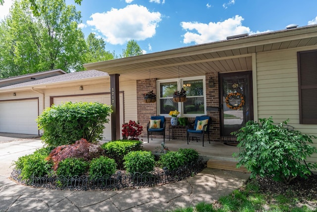 5717 Bayswater Pl, South Bend, IN 46614 - property entrance with covered porch, a garage, and brick siding