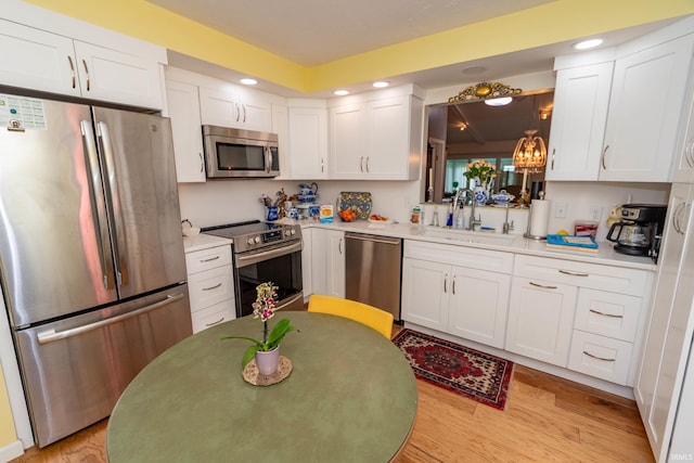 5717 Bayswater Pl, South Bend, IN 46614 - kitchen with appliances with stainless steel finishes, a sink, white cabinetry, light countertops, and recessed lighting