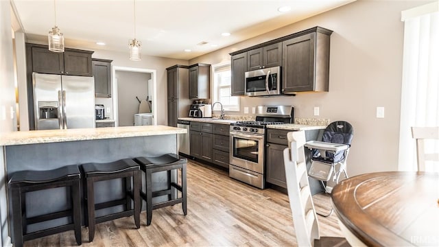 2014 Buell Dr, Angola, IN 46703 - kitchen featuring appliances with stainless steel finishes, light wood-style flooring, washer and dryer, dark brown cabinetry, and recessed lighting
