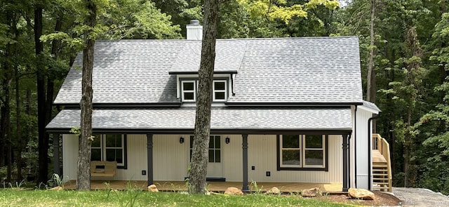 7017 S Harmony Rd, Bloomington, IN 47403 - view of front facade with a shingled roof, a chimney, covered porch, and a wooded view