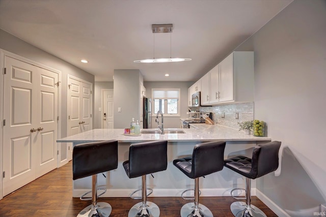 1881 E Eagle Bay Dr, Bloomington, IN 47401 - kitchen with a sink, appliances with stainless steel finishes, a peninsula, dark wood-type flooring, and recessed lighting