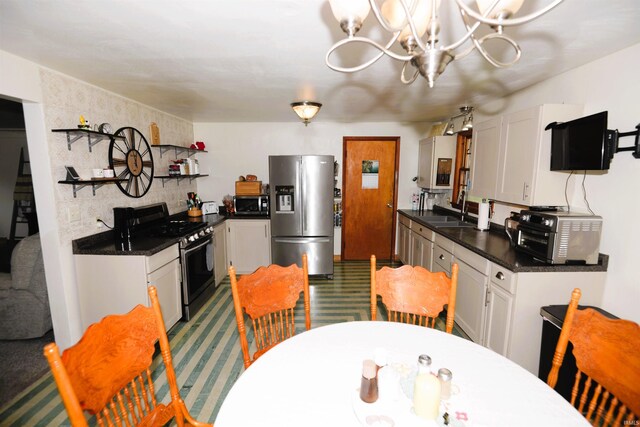 328 N Harding Ave, Mishawaka, IN 46544 - kitchen with appliances with stainless steel finishes, a sink, dark countertops, a chandelier, and white cabinetry