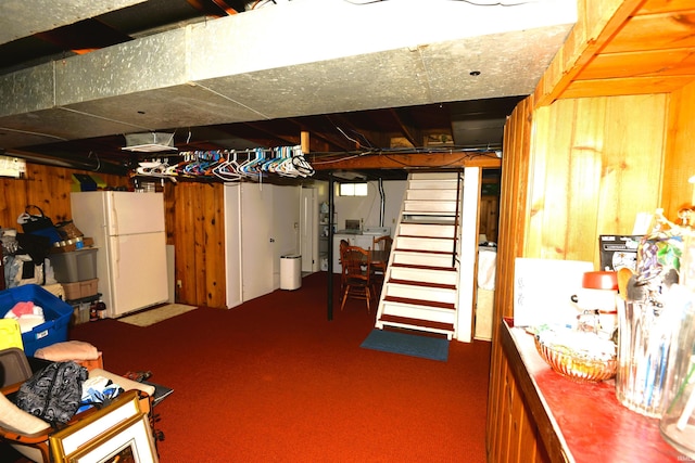 328 N Harding Ave, Mishawaka, IN 46544 - unfinished basement featuring freestanding refrigerator, stairway, wood walls, and carpet floors
