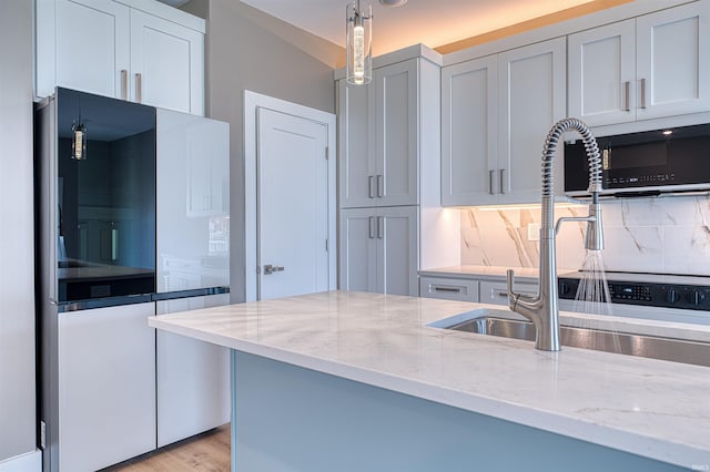 3605 Sand Dr, Newburgh, IN 47630 - kitchen with tasteful backsplash, light stone counters, pendant lighting, and light wood-style floors