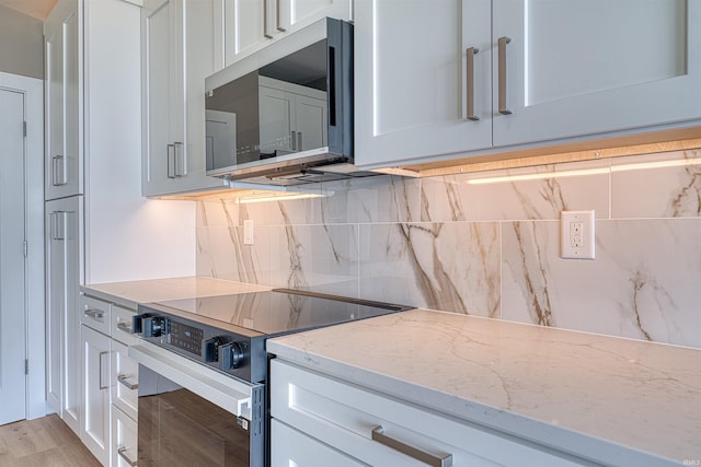 3605 Sand Dr, Newburgh, IN 47630 - kitchen featuring electric range oven, stainless steel microwave, decorative backsplash, and white cabinets