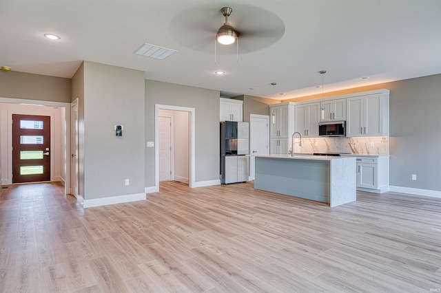 3605 Sand Dr, Newburgh, IN 47630 - kitchen with fridge, a sink, baseboards, a ceiling fan, and an island with sink