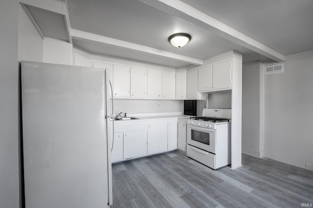 1437 Oakland St, Fort Wayne, IN 46808 - kitchen featuring white appliances, light wood-style floors, a sink, and white cabinets