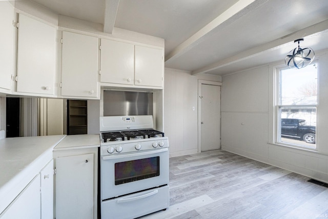 1437 Oakland St, Fort Wayne, IN 46808 - kitchen with gas range gas stove, light wood-style flooring, beamed ceiling, white cabinets, and light countertops