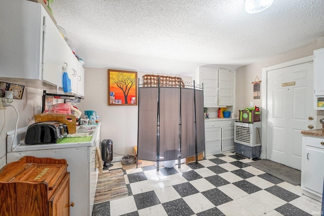 1437 Oakland St, Fort Wayne, IN 46808 - kitchen with light floors, white cabinetry, a textured ceiling, and light countertops