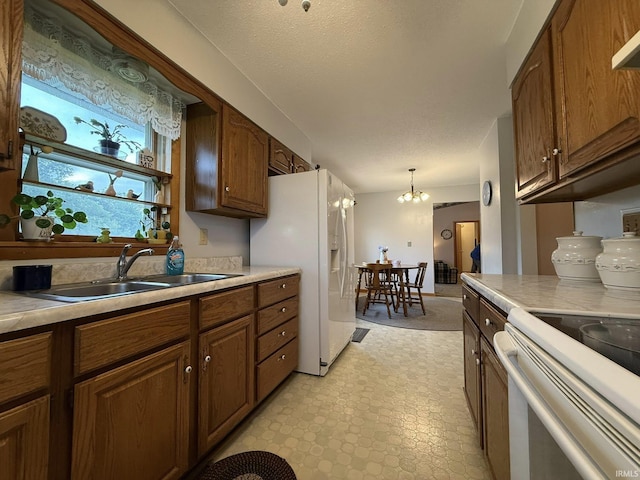 6311 N Camp Arthur Rd, Bruceville, IN 47516 - kitchen with a sink, light countertops, white appliances, and a chandelier
