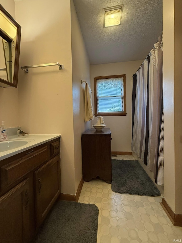 6311 N Camp Arthur Rd, Bruceville, IN 47516 - full bathroom featuring tile patterned floors, a textured ceiling, vanity, a shower with curtain, and baseboards