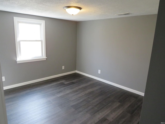 2607 S Airport Rd, Monticello, IN 47960 - empty room featuring a textured ceiling, dark wood-style flooring, and baseboards