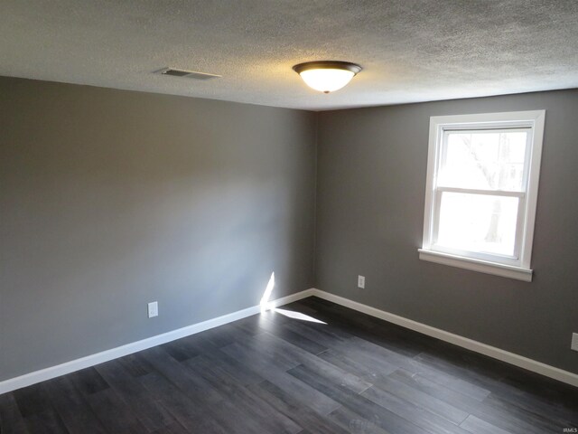 2607 S Airport Rd, Monticello, IN 47960 - spare room featuring dark wood-style floors, a textured ceiling, and baseboards