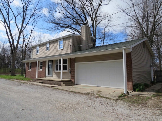 2607 S Airport Rd, Monticello, IN 47960 - view of front facade with brick siding, covered porch, a chimney, a garage, and dirt driveway