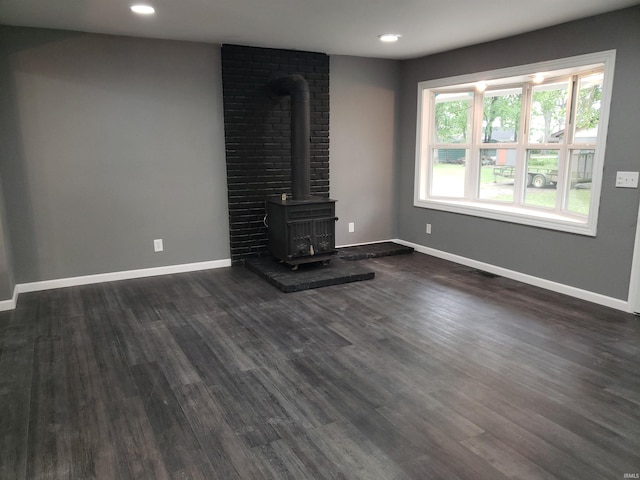 2607 S Airport Rd, Monticello, IN 47960 - unfurnished living room with a wood stove, baseboards, dark wood-style floors, and recessed lighting