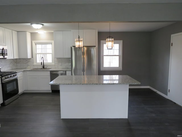 2607 S Airport Rd, Monticello, IN 47960 - kitchen with stainless steel appliances, a sink, tasteful backsplash, a kitchen island, and light stone counters