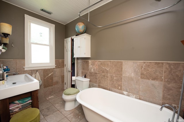 1422 Virginia St, Lafayette, IN 47905 - full bath featuring tile walls, a wainscoted wall, a soaking tub, toilet, and tile patterned floors