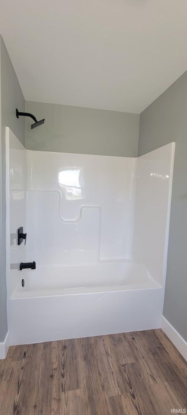 377 N 3rd St, Montgomery, IN 47558 - full bathroom with wood finished floors, shower / bathtub combination, and baseboards