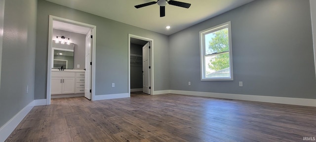 377 N 3rd St, Montgomery, IN 47558 - unfurnished bedroom with a spacious closet, a sink, dark wood-style floors, connected bathroom, and baseboards