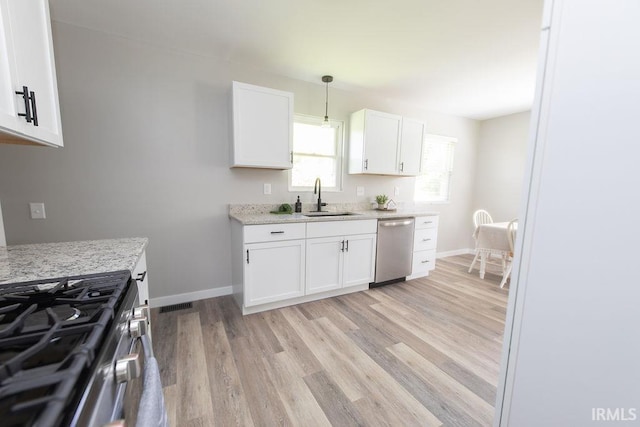 904 Hall Ave, Oolitic, IN 47446 - kitchen featuring stainless steel appliances, a sink, light wood-style floors, white cabinetry, and baseboards