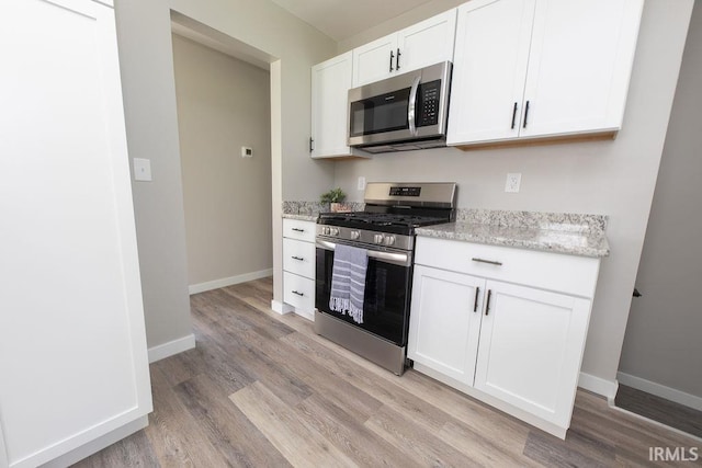 904 Hall Ave, Oolitic, IN 47446 - kitchen with appliances with stainless steel finishes, light wood-type flooring, white cabinetry, and light stone counters