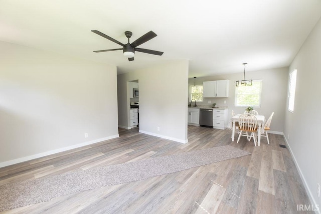 904 Hall Ave, Oolitic, IN 47446 - living room with light wood-style flooring, ceiling fan, and baseboards