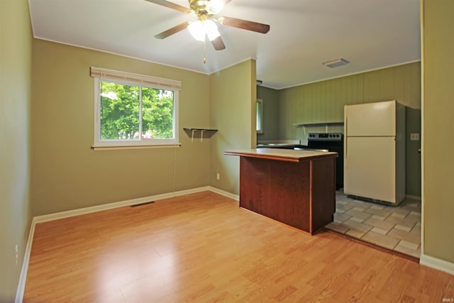 2301 E Delaware St, Evansville, IN 47711 - kitchen featuring freestanding refrigerator, light wood-type flooring, a peninsula, ceiling fan, and baseboards