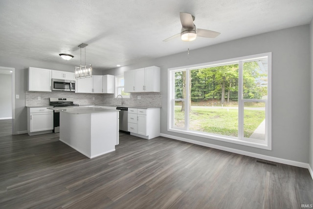 10974 County Road 10, Middlebury, IN 46540 - kitchen with stainless steel appliances, baseboards, white cabinets, light countertops, and decorative backsplash