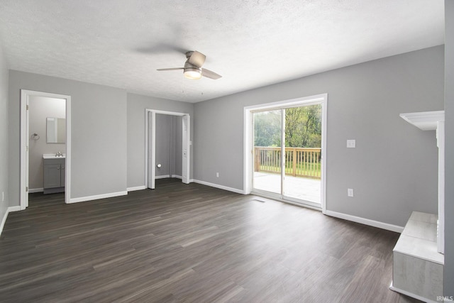 10974 County Road 10, Middlebury, IN 46540 - unfurnished bedroom featuring access to exterior, dark wood finished floors, baseboards, a sink, and a textured ceiling