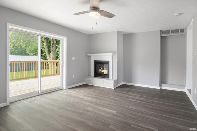 10974 County Road 10, Middlebury, IN 46540 - unfurnished living room with dark wood-style floors, a glass covered fireplace, baseboards, and ceiling fan