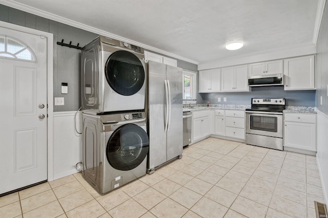 1300 Belvedere Dr, Kokomo, IN 46902 - kitchen featuring stainless steel appliances, stacked washer / dryer, crown molding, light countertops, and white cabinets