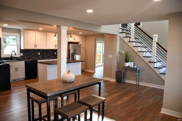 7019 Bull Rapids Rd, Woodburn, IN 46797 - kitchen with black dishwasher, decorative backsplash, a sink, stainless steel fridge, and dark countertops