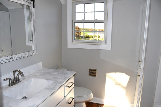 7019 Bull Rapids Rd, Woodburn, IN 46797 - bathroom with vanity, toilet, baseboards, and wood finished floors