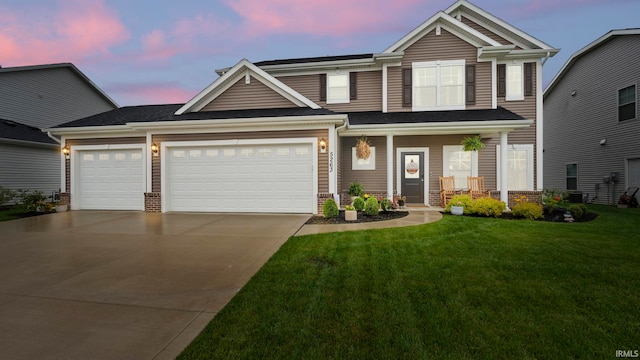 5263 Gadwall Pass, Fort Wayne, IN 46818 - view of front of house featuring driveway, a front yard, covered porch, and a garage