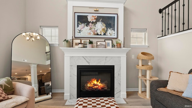 5263 Gadwall Pass, Fort Wayne, IN 46818 - living room featuring wood finished floors, a fireplace, baseboards, ornate columns, and a towering ceiling
