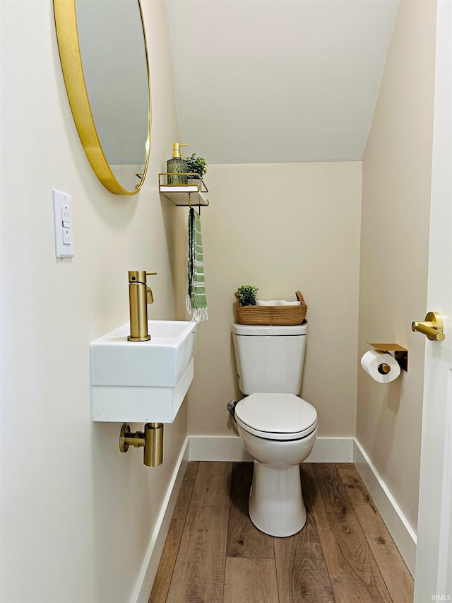 1412 E National Hwy, Washington, IN 47501 - bathroom featuring toilet, wood finished floors, baseboards, and vaulted ceiling