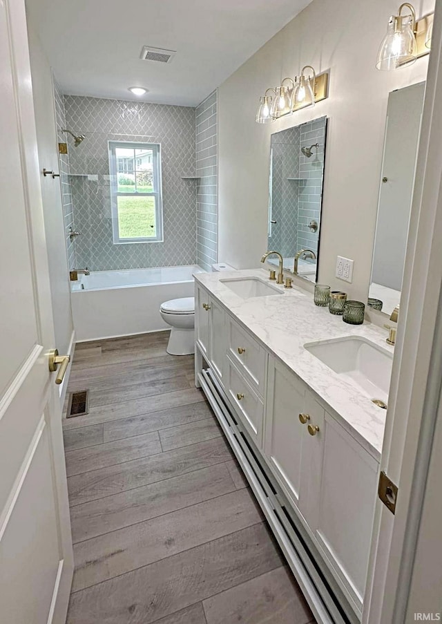1412 E National Hwy, Washington, IN 47501 - full bathroom with bathtub / shower combination, toilet, wood finished floors, and double vanity