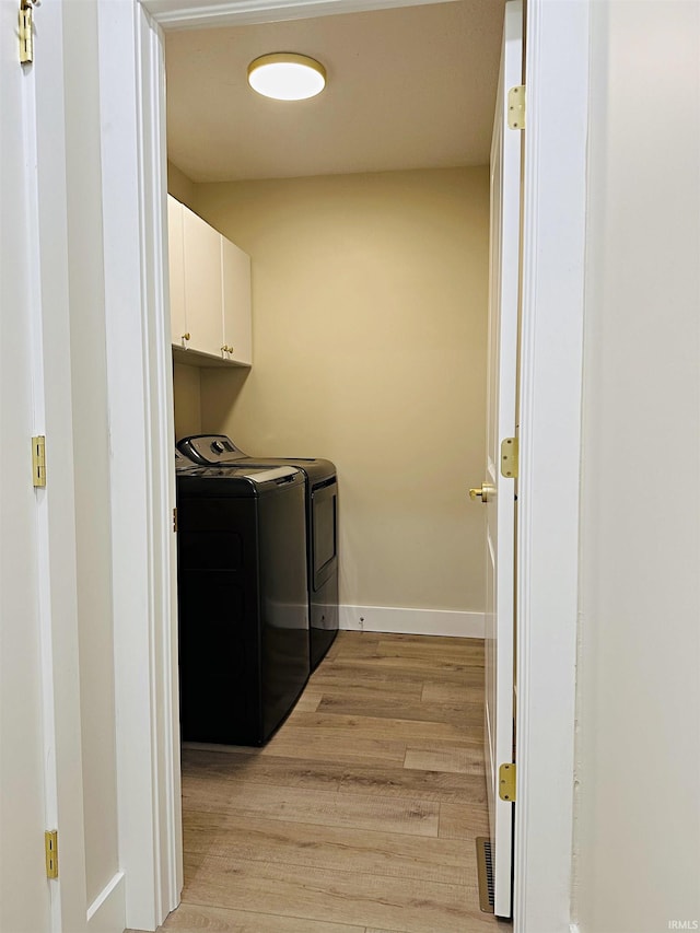 1412 E National Hwy, Washington, IN 47501 - washroom with cabinet space, washer and clothes dryer, light wood-style floors, and baseboards